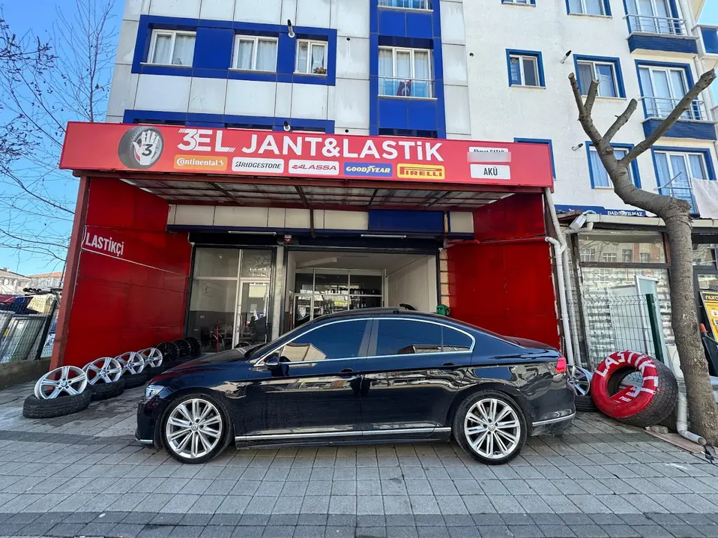 3 El Jant ve Lastik dükkânının cephesi, önünde jantlar ve bir otomobil