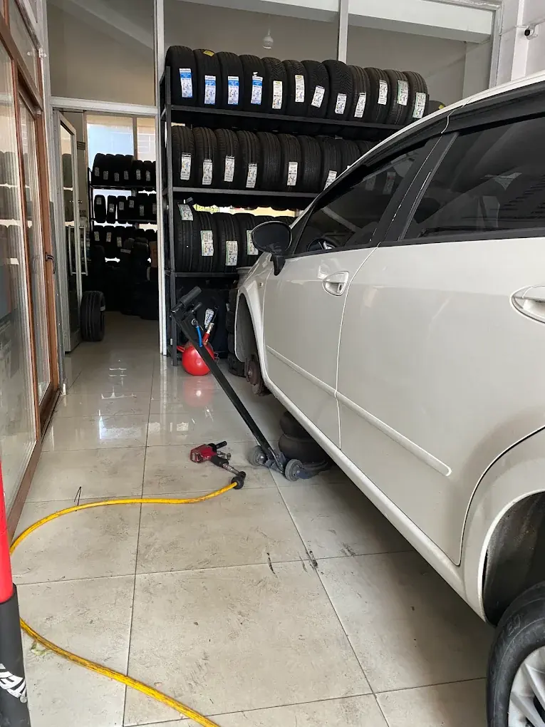 Dükkân içinde lastik rafları önünde krikoya alınmış otomobil