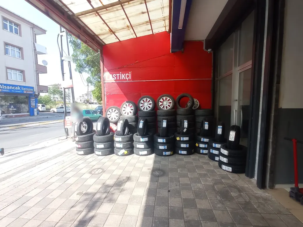 Dükkân önünde istiflenmiş yeni lastikler ve jantlar